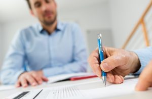 Applicant signing a surety bond agreement in front of the surety agent