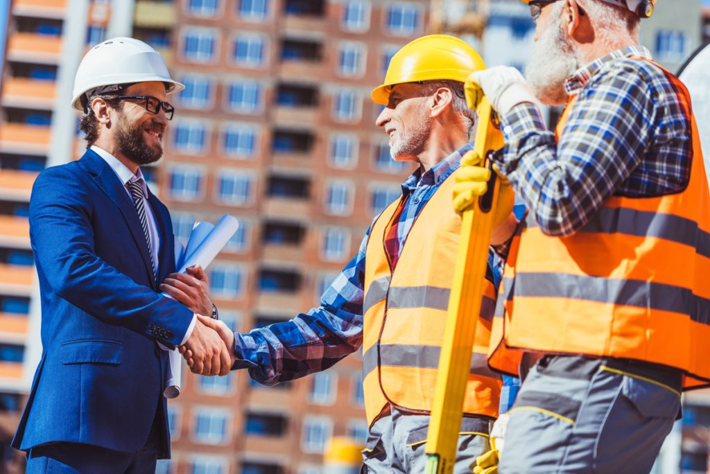 Contractor with a bid bond shaking hands with project owner
