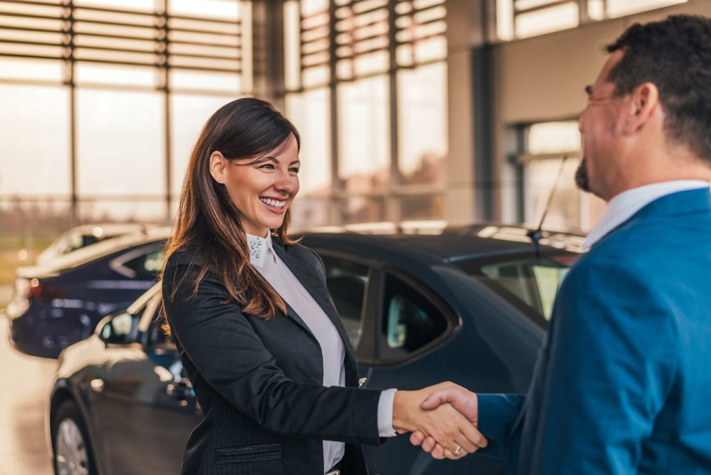 Kansas auto dealer shakes hands with customer
